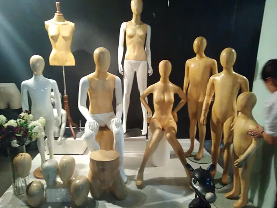 Maniquí niño de fibra de vidrio sentado con las manos levantadas